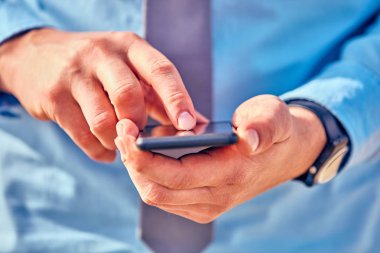 İş adamı sokakta onun Smartphone kullanarak.