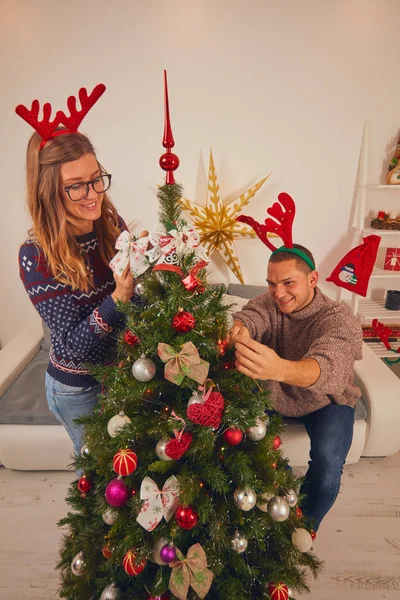 Happy couple decorating tree for New Year 's / Christmas eve . — стоковое фото