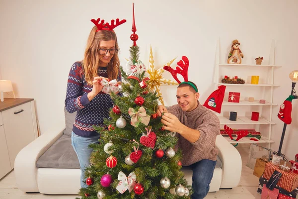 Glückliches Paar schmückt Baum für Neujahr / Heiligabend. — Stockfoto