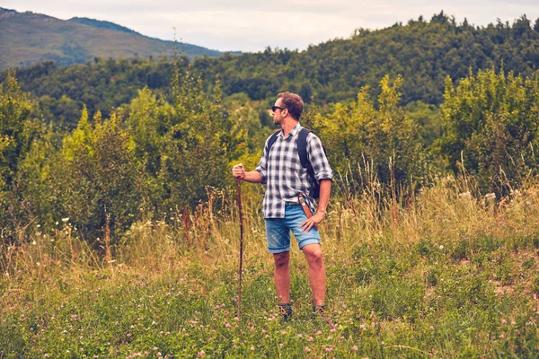 Hiker posing with knife on the belt in a meadow. — Stock Photo, Image