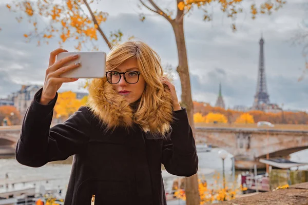 Mädchen benutzt Handy mit Pariser Hintergrund und Eiffelturm — Stockfoto