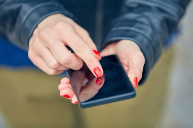 Sokakta modern akıllı telefon kullanan bir kadın..