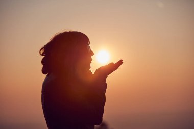 Şafak/günbatımı zaman zevk dua silah ile kadın.