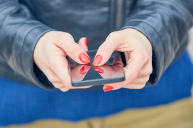 Sokakta modern akıllı telefon kullanan bir kadın..