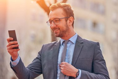 İş adamı sokakta onun Smartphone kullanarak.