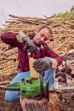 Testere ile kesme woods yığını ile oduncu.