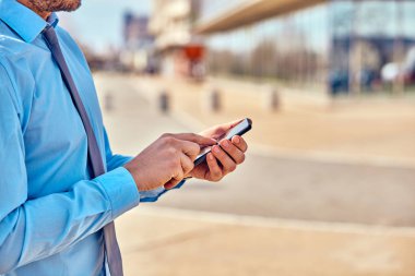 İş adamı sokakta onun Smartphone kullanarak.