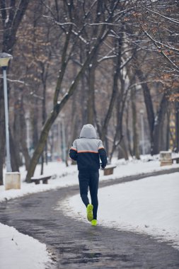 Soğuk bir kış karlı gün açık havada adam jogging.