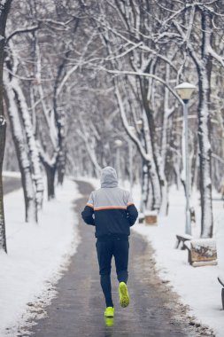 Soğuk bir kış karlı gün açık havada adam jogging.