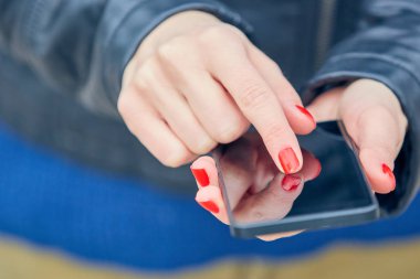 Sokakta modern akıllı telefon kullanan bir kadın..