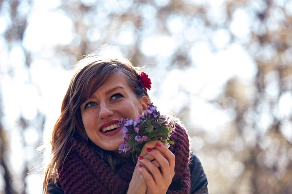 Cute young girl smelling nice bouquet of flowers in nature. — Stock Photo, Image