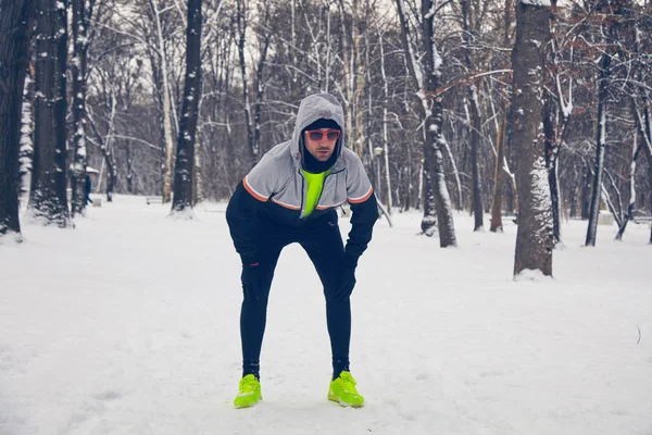Чоловік бігає в засніженому парку і холодної погоди . — стокове фото