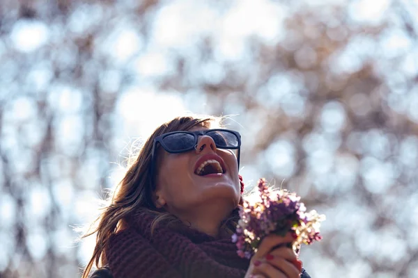 自然の中の花の素敵な花束を臭いがするかわいい若い女の子. — ストック写真