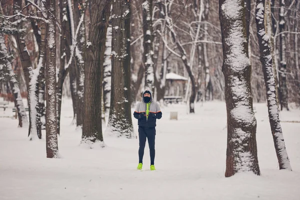 Człowiek jogging w zimnej zimie śnieżny dzień na zewnątrz. — Zdjęcie stockowe