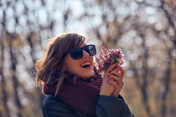 Cute young girl smelling nice bouquet of flowers in nature. — Stock Photo, Image