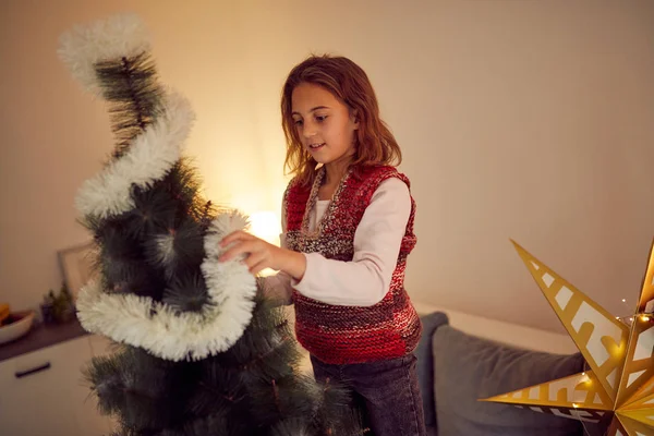 クリスマス/新年のために光沢のある装飾を準備する子供の女の子 — ストック写真