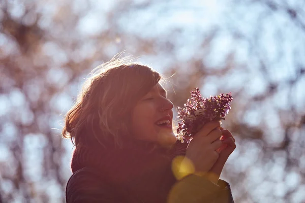 Cute young girl smelling nice bouquet of flowers in nature. — Stock Photo, Image