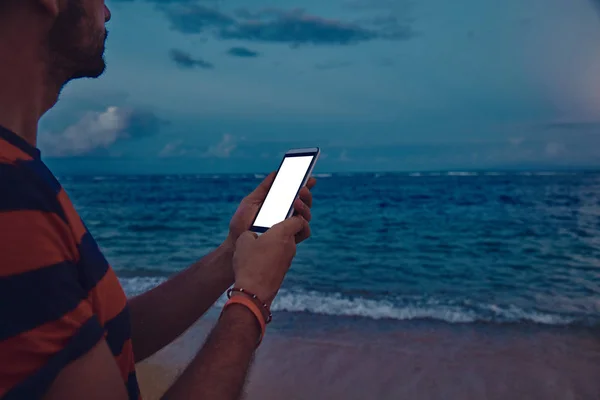 Hombre usando el teléfono celular en una playa de arena del océano . —  Fotos de Stock