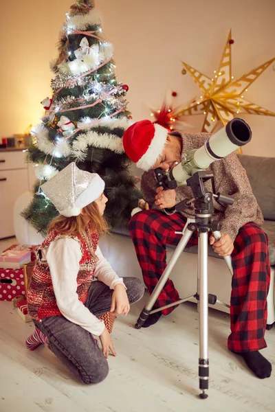 Vater und Tochter schauen zu Weihnachten ins Fernrohr / Neu — Stockfoto