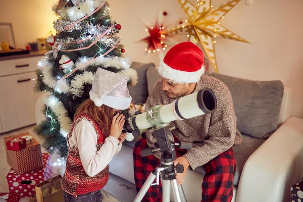 クリスマスに望遠鏡を見る父と娘/新しい — ストック写真