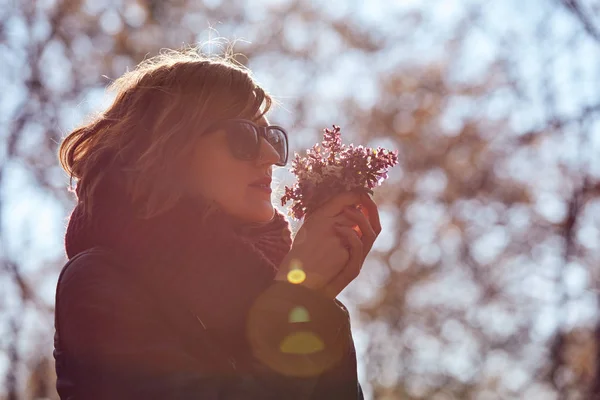 Симпатична молода дівчина пахне гарним букетом квітів у природі . — стокове фото