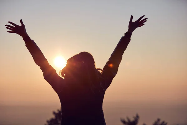 Frau mit weit geöffneten Armen genießt den Sonnenaufgang / Sonnenuntergang. — Stockfoto