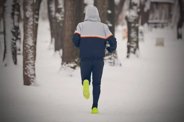 Człowiek jogging w zimnej zimie śnieżny dzień na zewnątrz. — Zdjęcie stockowe