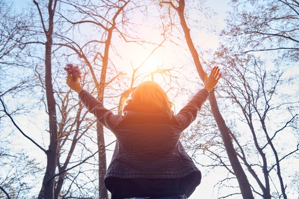 Frau hält Blumen mit weit geöffneten Armen. — Stockfoto