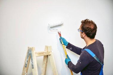 Ev içinde işçi boyama duvarları-yenileme düzeltmeleri.