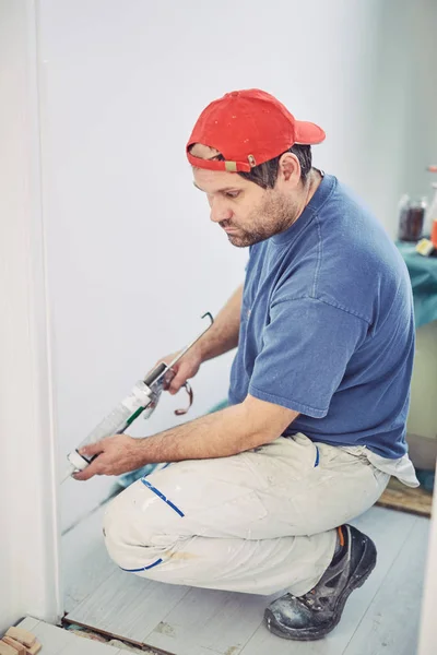 Работник, использующий силикон для стен и плитки внутри дома - рен — стоковое фото