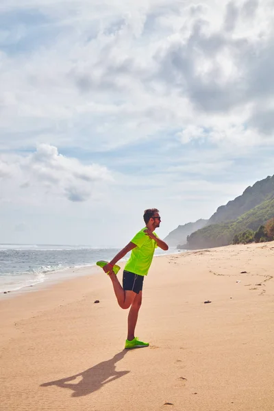 Deportista estirándose en una playa de arena tropical . — Foto de Stock