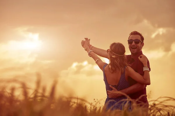 Paar bei Sonnenuntergang / Sonnenaufgang in einem Weizenfeld. — Stockfoto