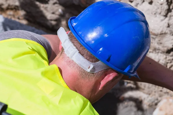 Kraftigt arbete för en byggarbetare på byggarbetsplatsen. — Stockfoto