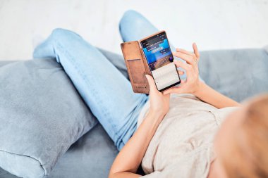 Evin içinde akıllı telefon kullanan bir kadın..