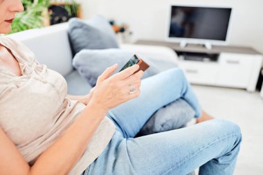 Evin içinde akıllı telefon kullanan bir kadın..