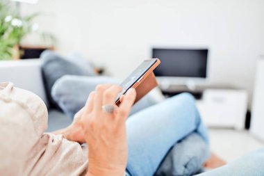 Evin içinde akıllı telefon kullanan bir kadın..