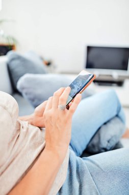 Evin içinde akıllı telefon kullanan bir kadın..