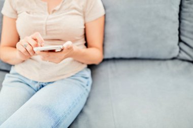 Evin içinde akıllı telefon kullanan bir kadın..