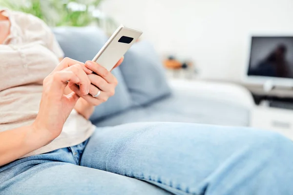 Vrouw met een smartphone in het appartement. — Stockfoto