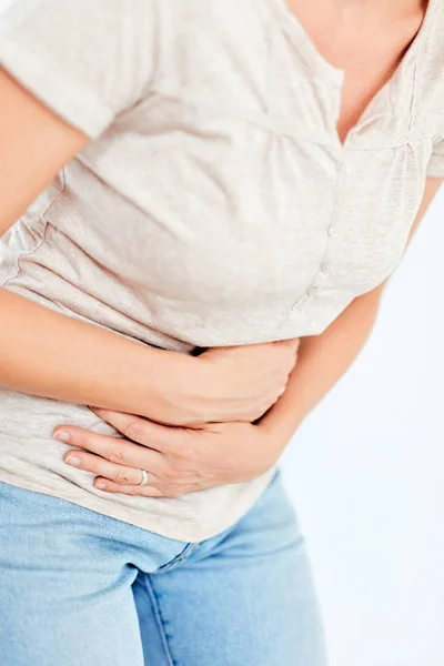 Woman with stomach/ hip issues / problems on the white backgroun Stock Picture