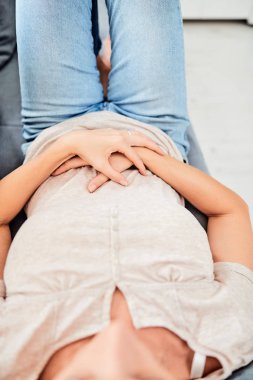 Kanepede yatarken mide sorunları olan bir kadın..