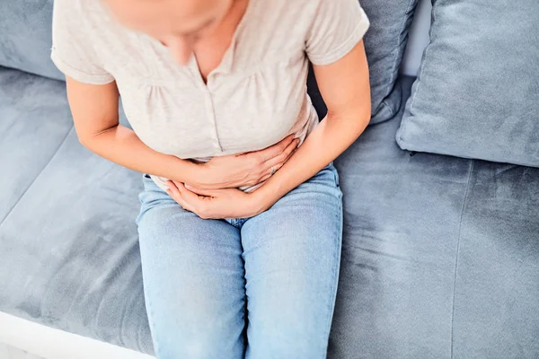 Frau mit Magenproblemen beim Sitzen auf der Couch — Stockfoto