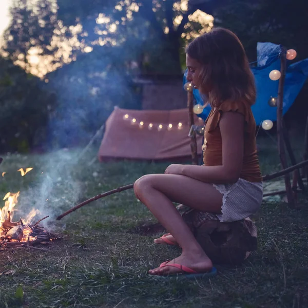 Kid meisje maken kampvuur in de avond tijd. — Stockfoto