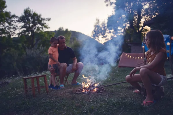 Padre con bambini che fanno un fuoco da campeggio nel cortile . — Foto Stock