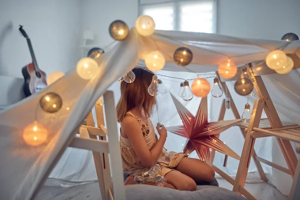 Menina brincando e fazendo uma tenda de casa no quarto . — Fotografia de Stock