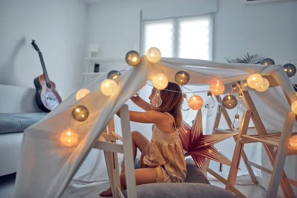 Menina brincando e fazendo uma tenda de casa no quarto . — Fotografia de Stock