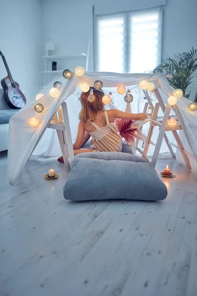 Meisje spelen en het maken van een huis tent in de kamer. — Stockfoto