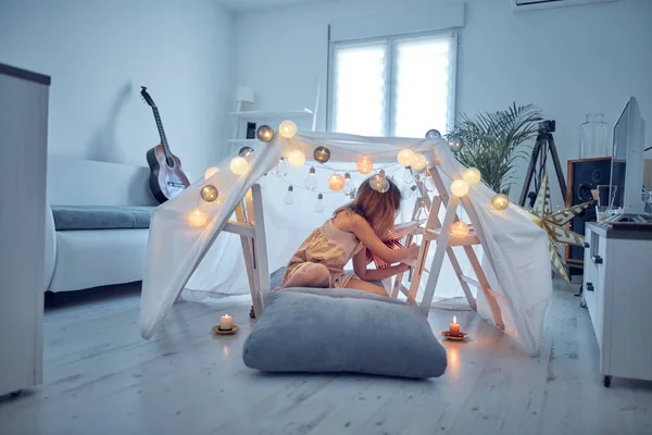 Meisje spelen en het maken van een huis tent in de kamer. — Stockfoto