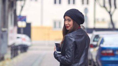 Şapkalı ve cep telefonlu genç bir kadın..