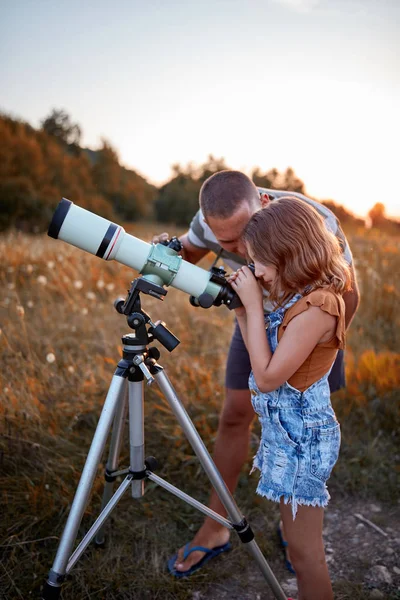 Vater und Tochter beobachten den Himmel mit dem Teleskop. — Stockfoto